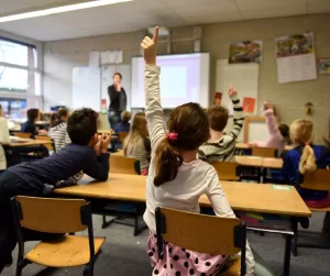 child raising her hand at school