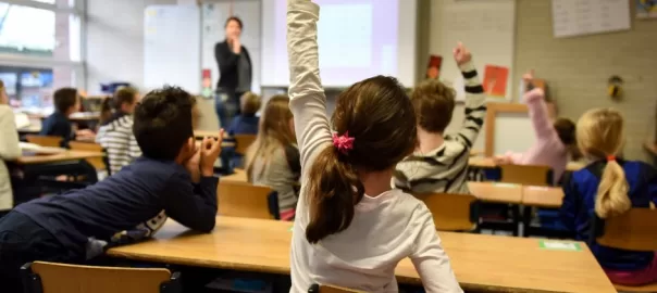 child raising her hand at school