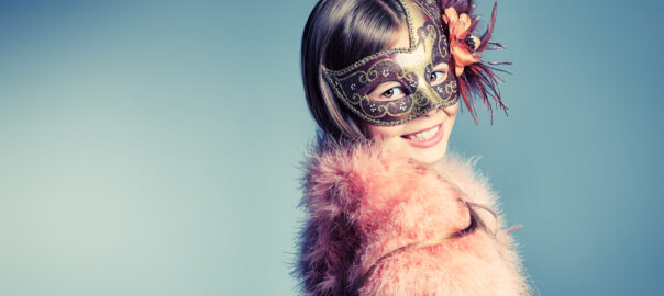Girl in festive dress and carnival mask posing